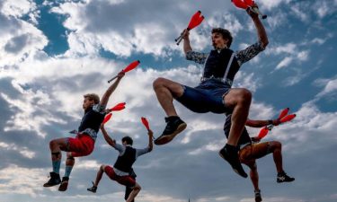 Quatuor Stomp suspended in the air while holding orange juggling pins